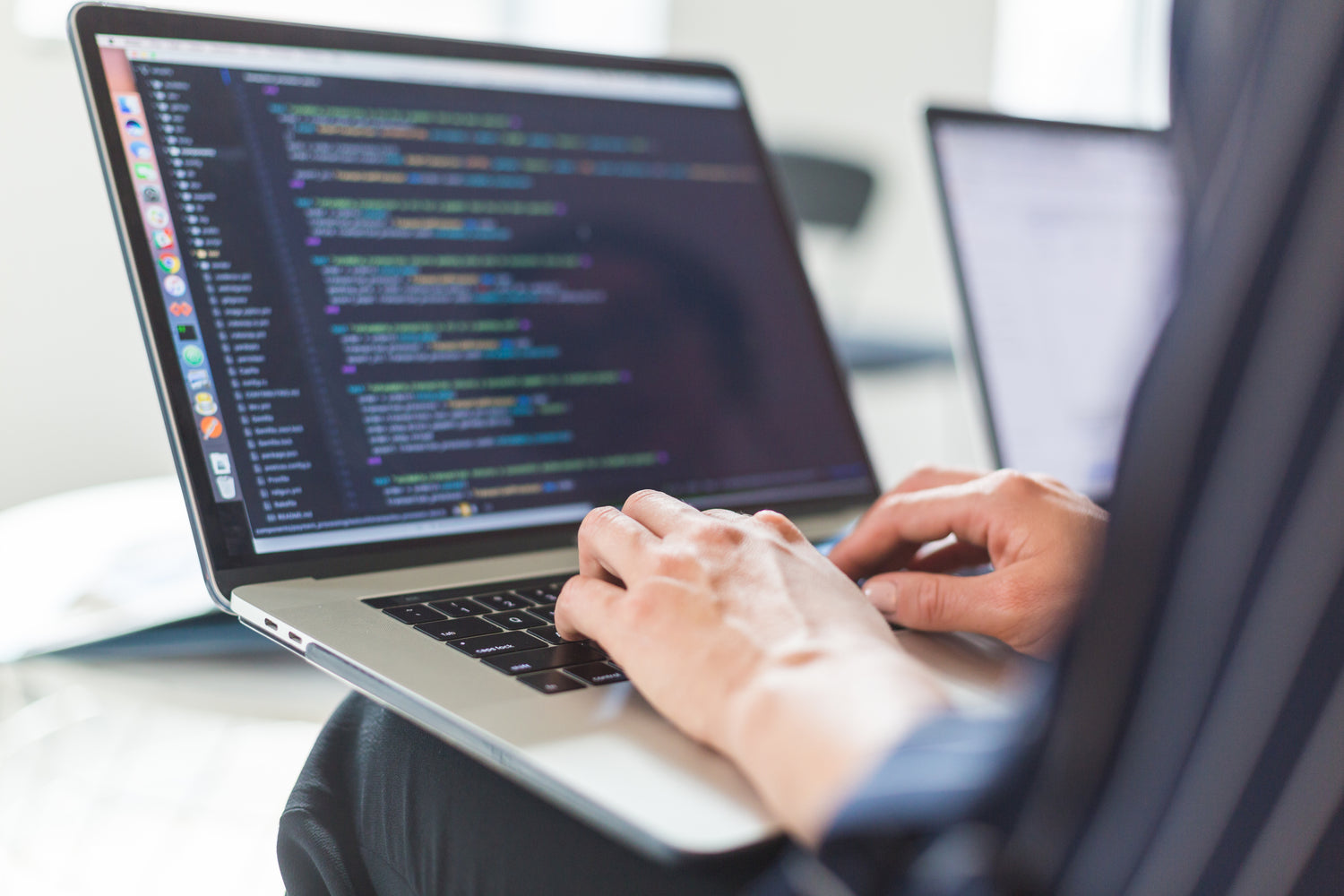 Person coding on a laptop.